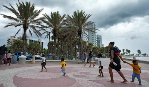 Families visiting Clearwater Beach make their way to the cars just before a squall line associated with Hurricane Idalia hit the area Tuesday, Aug. 29, 2023, in Clearwater, Fla. Residents along Florida's gulf coast are making preparations for the effects of Idalia. (AP Photo/Chris O'Meara)