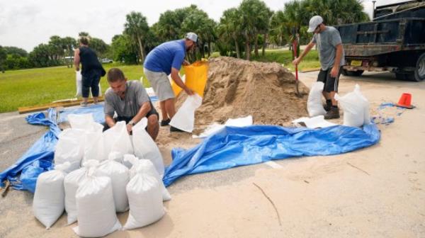 Flagler County residents fill sand bags, Tuesday, Aug. 29, 2023, in Flagler Beach, Fla., as they prepare for the arrival of Hurricane Idalia. (AP Photo/John Raoux)